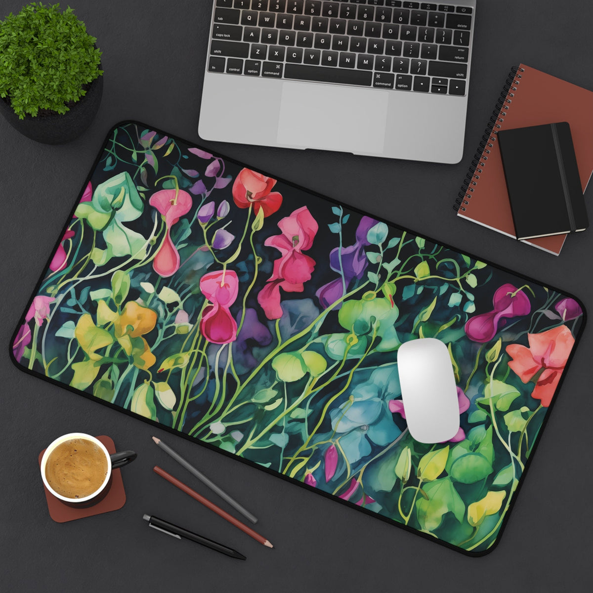 Watercolor Sweet Pea Flowers Desk Mat on a dark desk with laptop, mouse, coffee, pencils and notebooks, 12 × 22 inches.