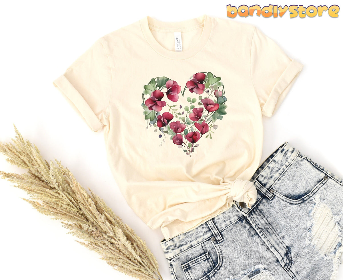 Watercolor Sweet Pea Heart T-Shirt in natural flat-laid beside dried grass and ripped jeans.