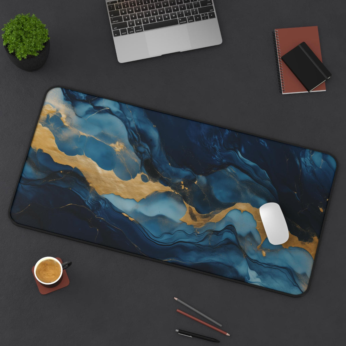 Abstract Marble Desk Mat 16 × 32 inches from above on a dark desk with laptop, plant, notebooks, coffee, pens and mouse.