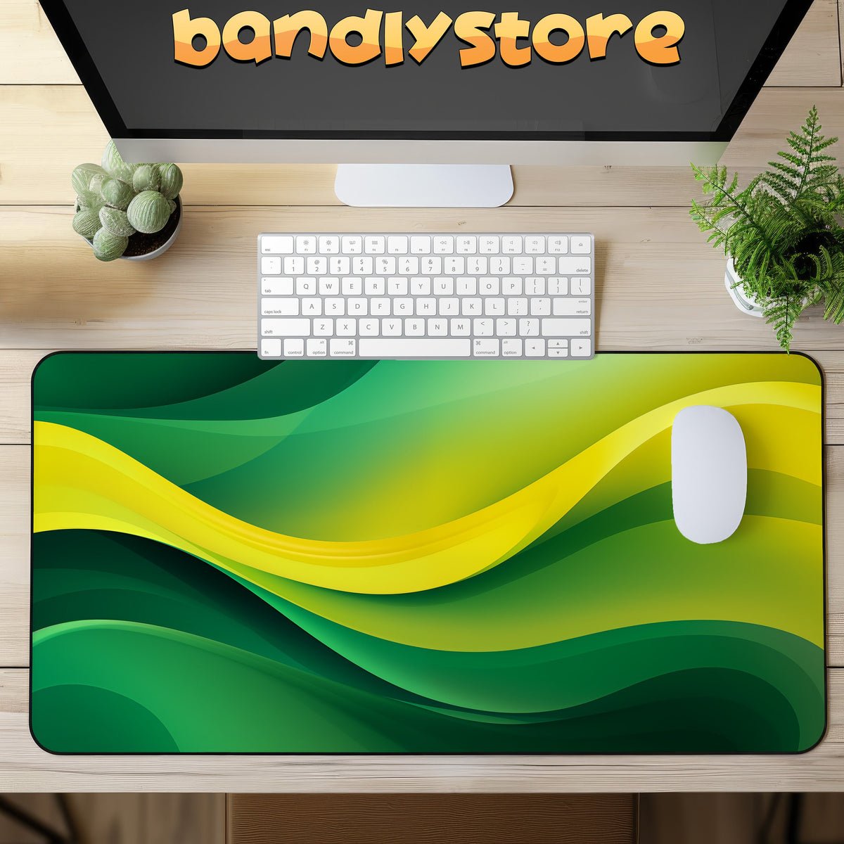 Abstract Desk Mat with green and yellow waves on a wooden desk with keyboard, mouse, monitor and plants, from above.