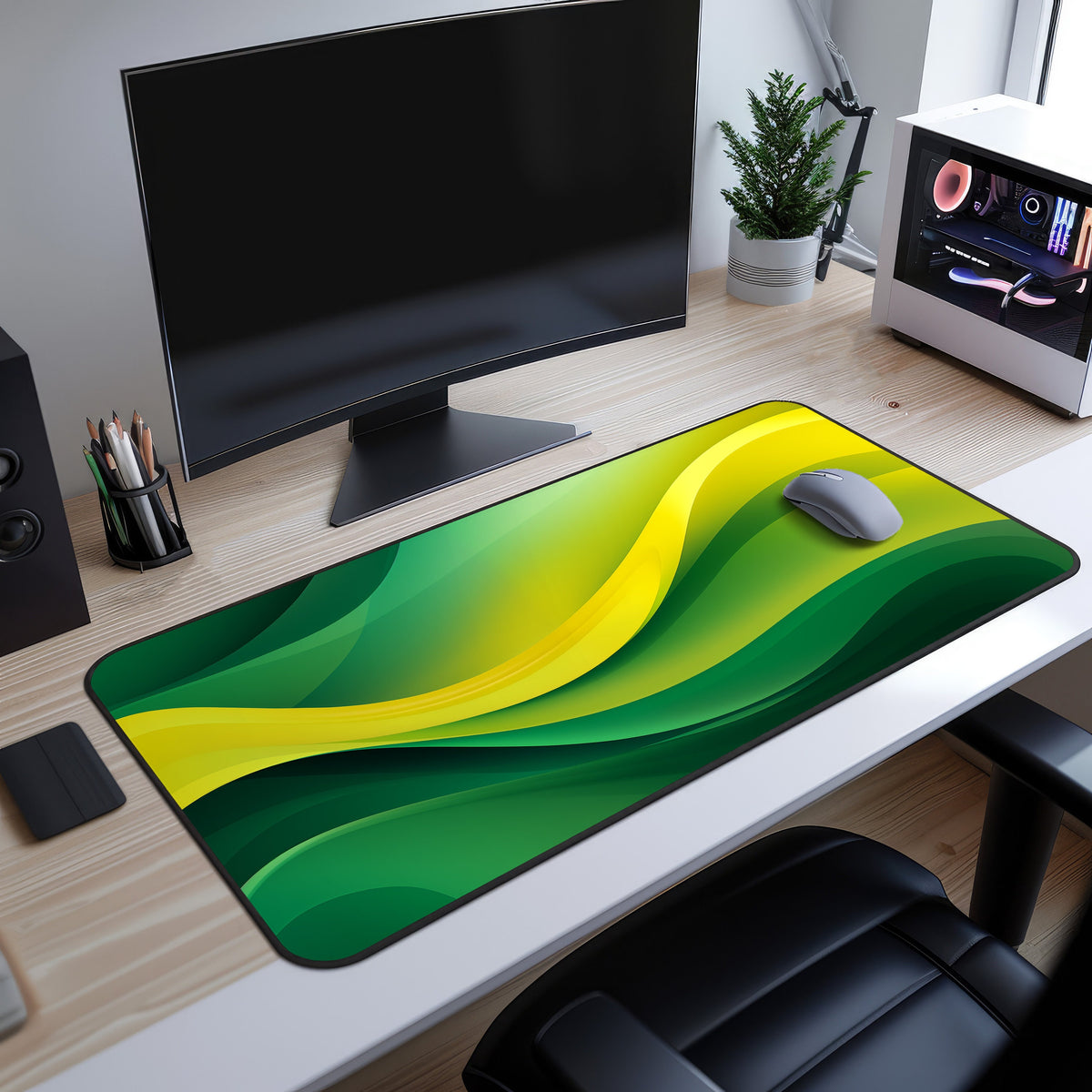 Abstract Desk Mat on a wood desk under a black monitor, grey mouse atop green-yellow waves, PC and plant nearby.