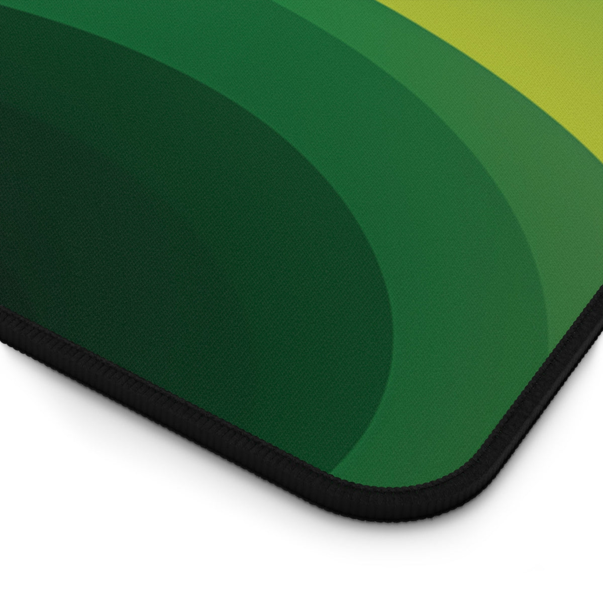 Abstract Desk Mat close-up of curved green bands fading to yellow on a black-edged corner.