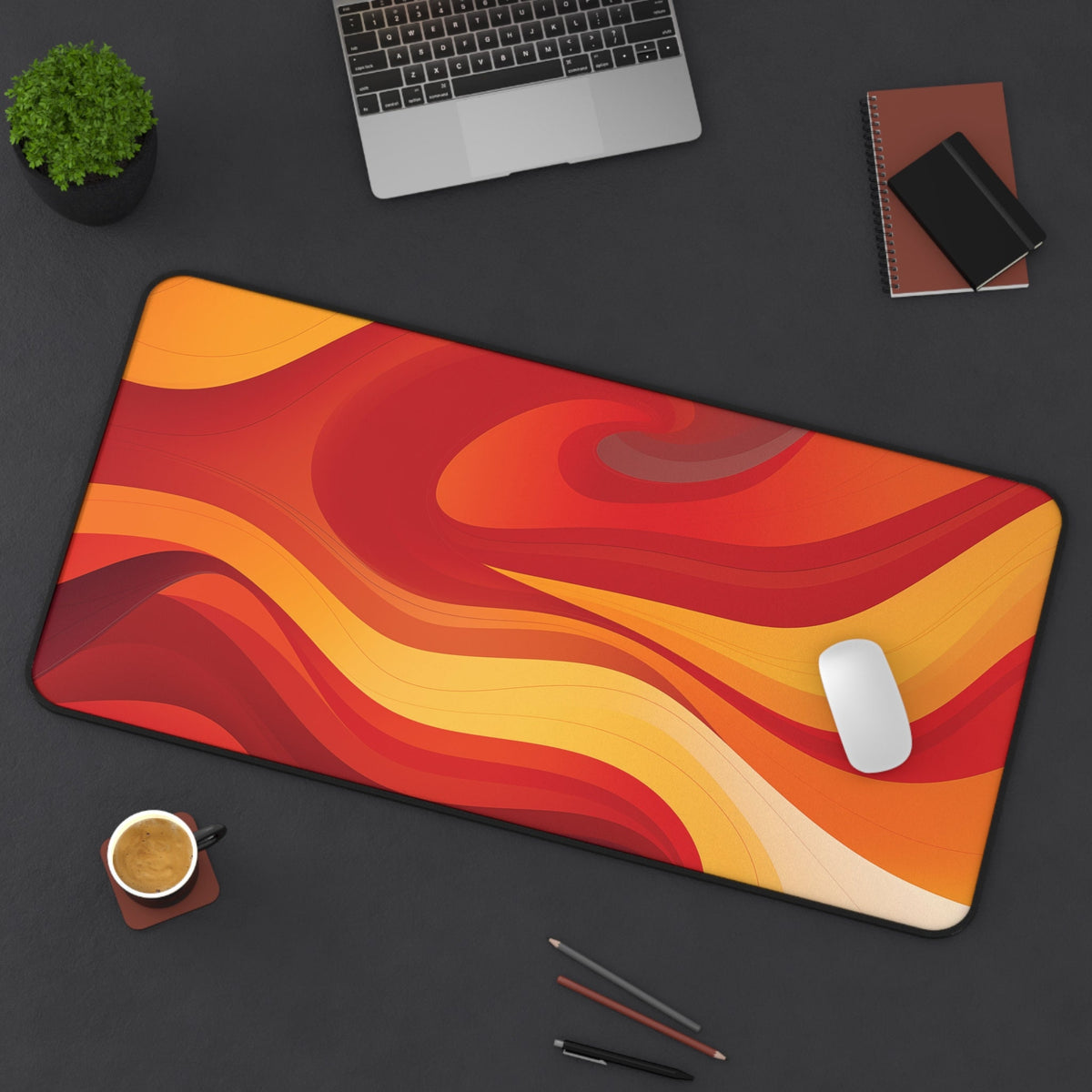 Abstract Lava Desk Mat in 16 × 32 inches top-down on a desk with laptop, plant, notebooks, coffee, pens and mouse.