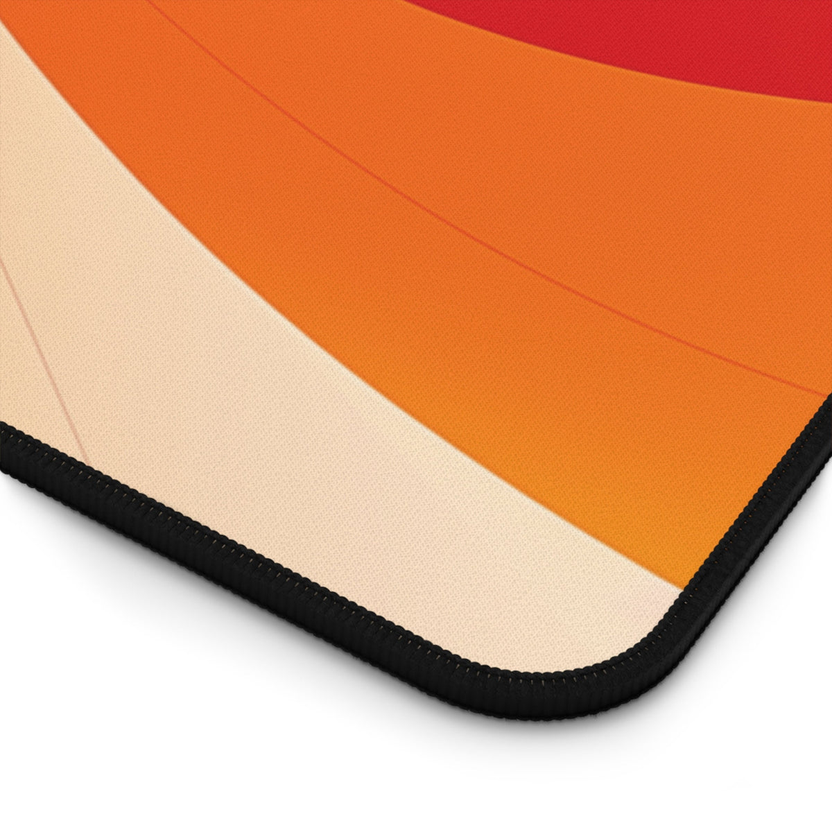 Abstract Lava Desk Mat corner detail showing curved orange-to-cream bands and black stitched edge.