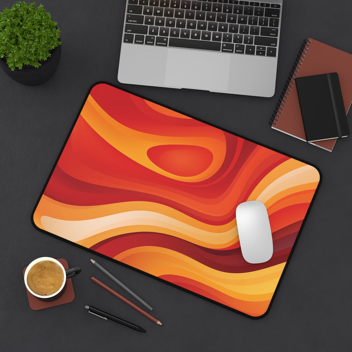 Abstract Lava Desk Mat 12 × 18 inches shown top-down on a desk with laptop, plant, notebooks, coffee, pens and mouse.