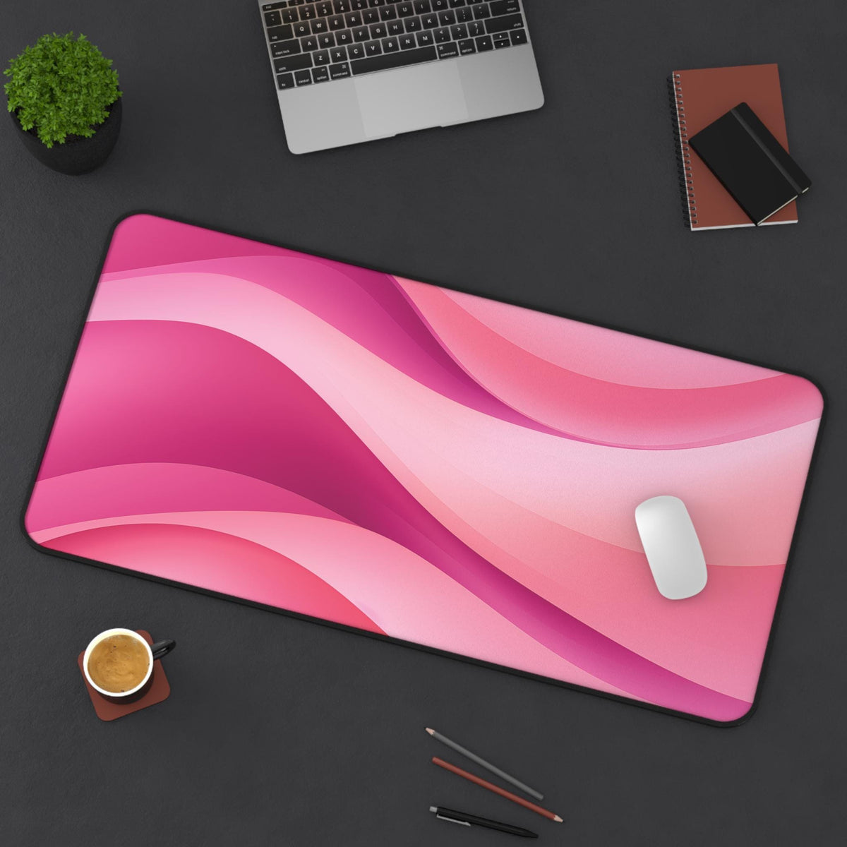 Abstract Desk Mat in pink waves on a dark desk with laptop, plant, coffee, notebooks and mouse, 16 × 32 inches