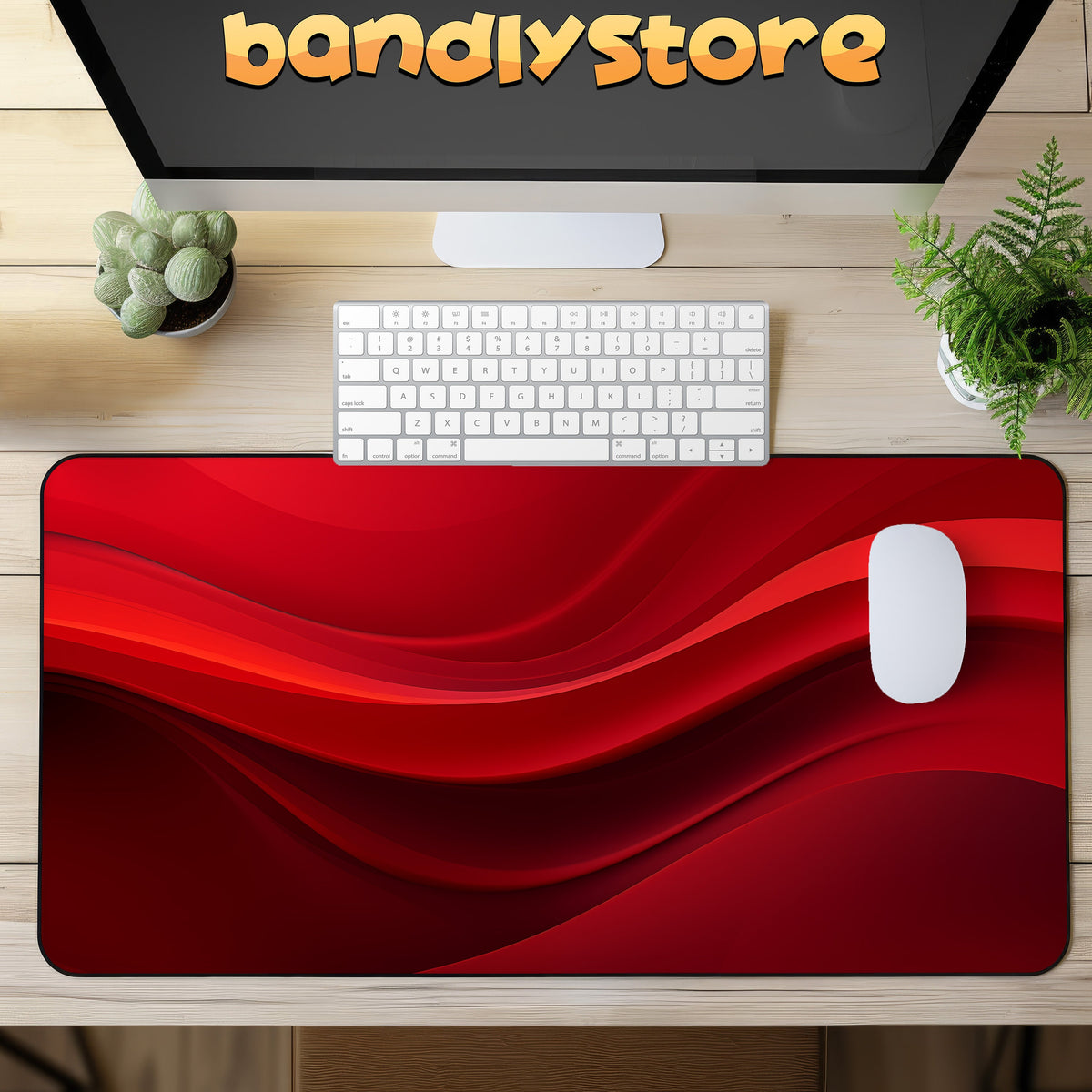 Abstract Red Wave Desk Mat in top-down view on a wooden desk with keyboard, mouse, monitor and plants.