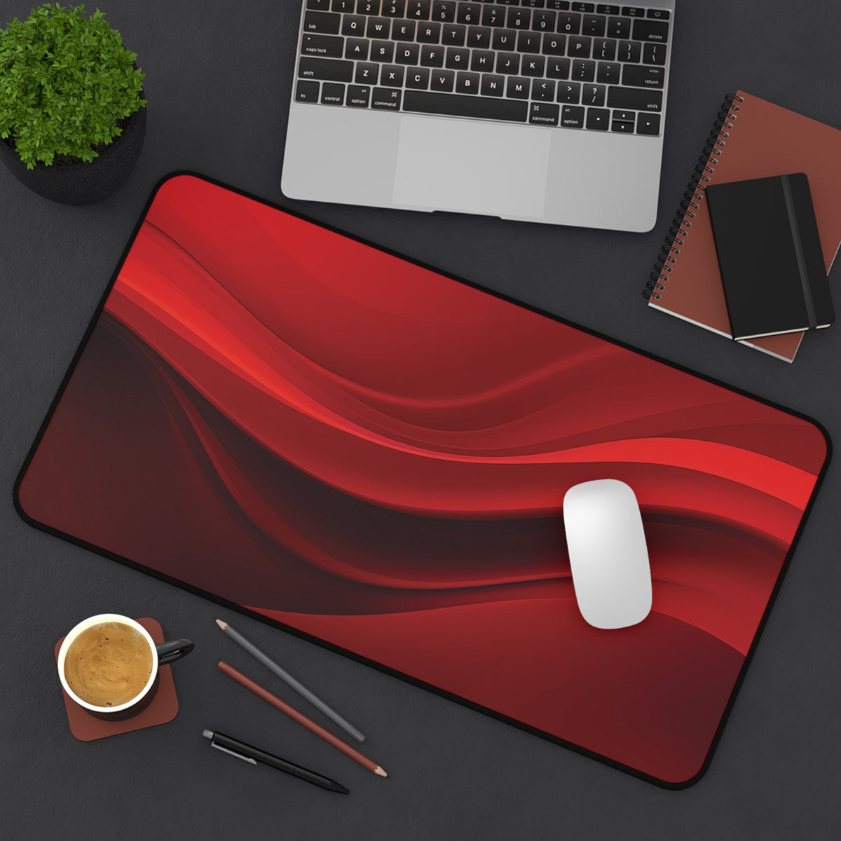 Abstract Red Wave Desk Mat 12 × 22 inches top-down on desk with laptop, plant, notebooks, coffee, pencils and mouse.