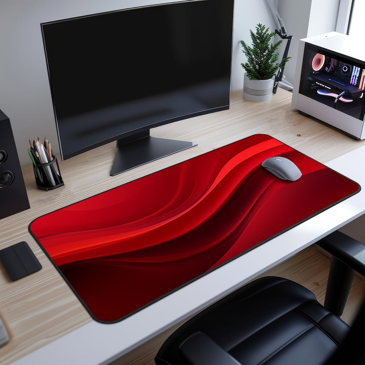 Abstract Red Wave Desk Mat on a desk in high-angle view beneath a monitor, mouse on it, plant and PC nearby.
