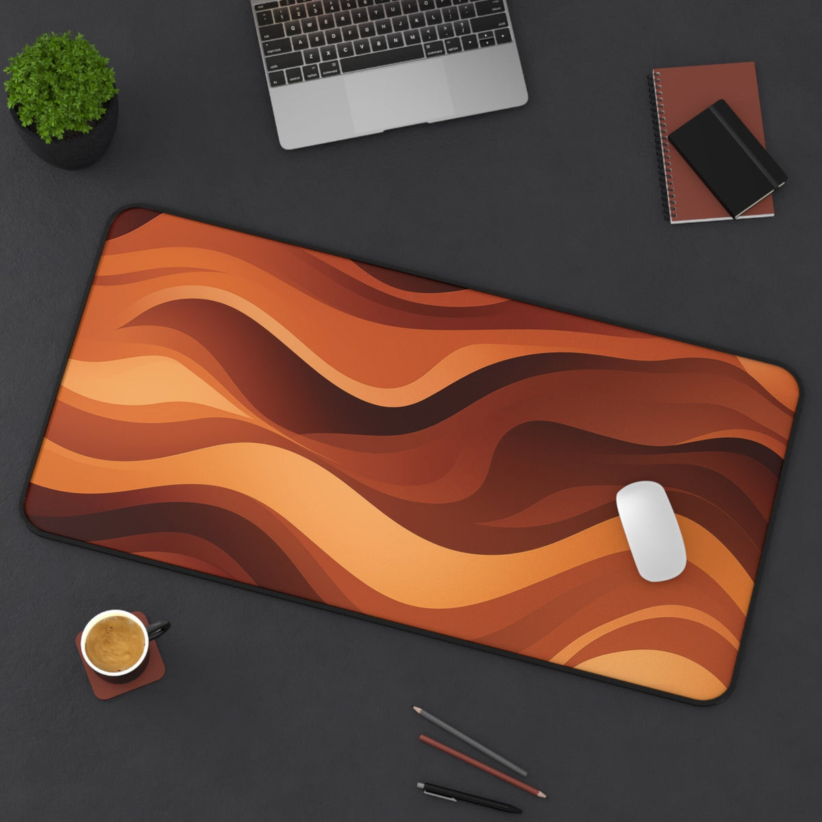 Abstract Wavy Desk Mat, 16 × 32 inches, top-down on dark desk with laptop, plant, coffee, notebooks, pens and mouse.