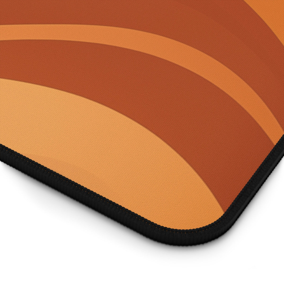 Abstract Wavy Desk Mat detail of its rounded corner and black stitched edge on a plain white background.