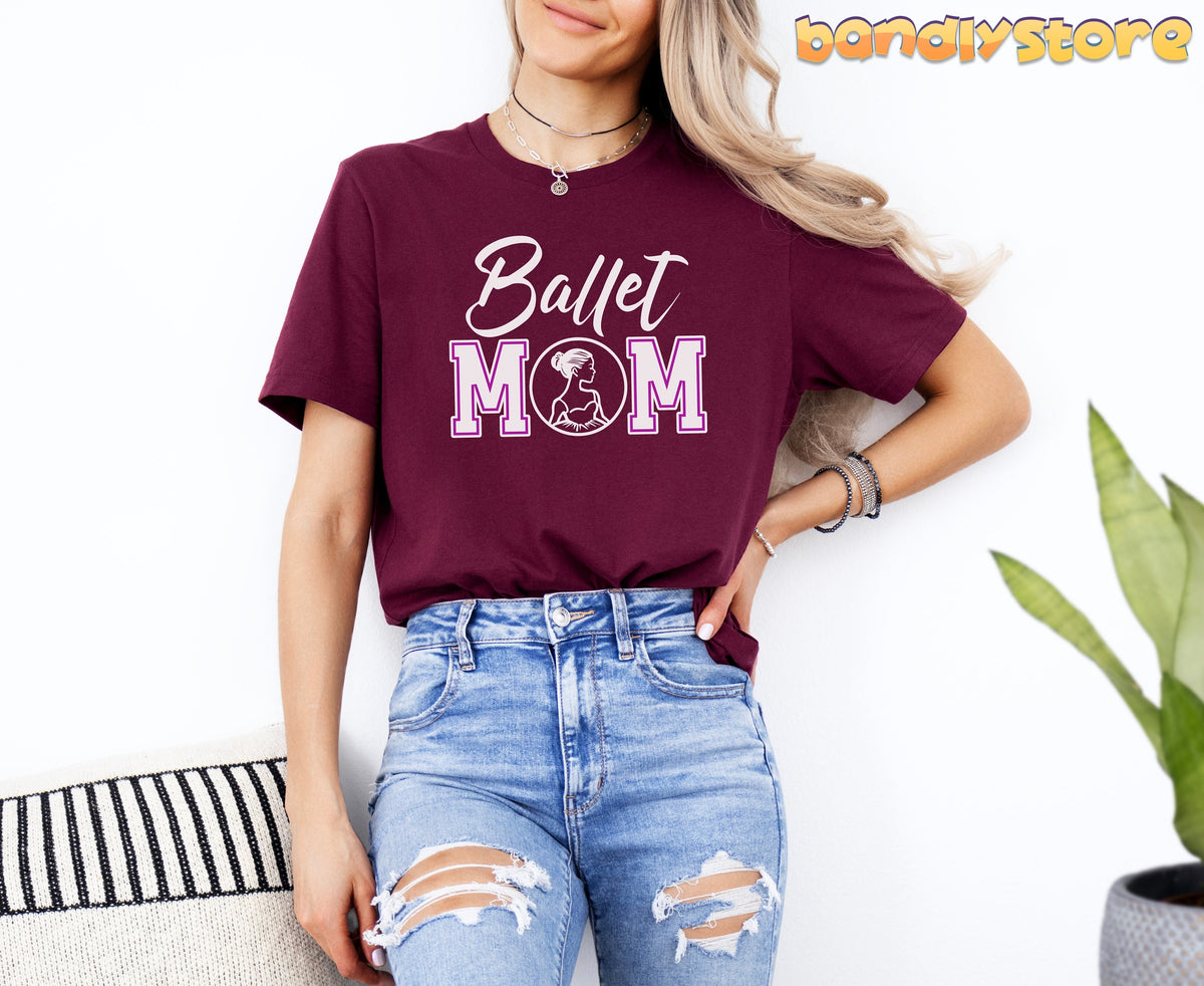 Ballet Mom T-Shirt in maroon on a model against a white wall with a plant and striped cushion.