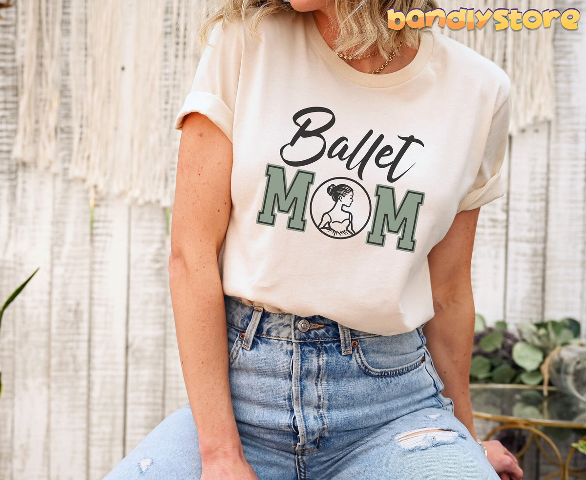 Ballet Mom T-Shirt in natural on a seated model against a white wood wall with macrame and plants.
