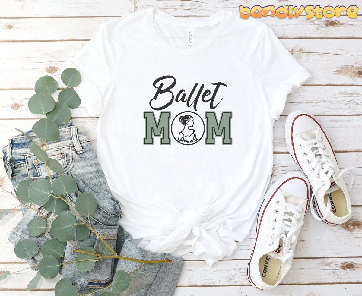 Ballet Mom T-Shirt in white laid flat on wood beside jeans, greenery and sneakers.