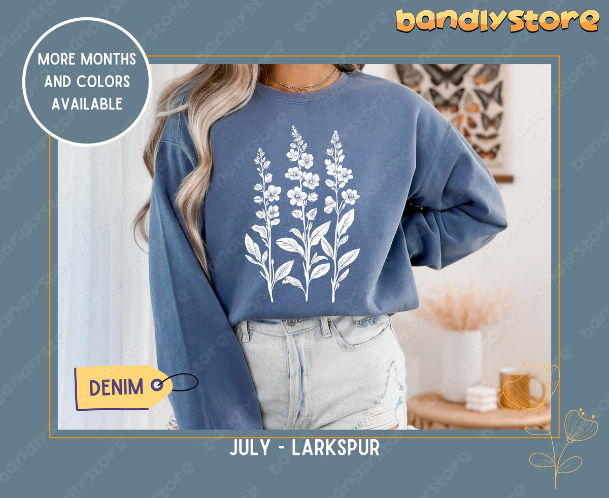 July Larkspur Birth Flower Sweatshirt in denim on a person indoors by butterfly art and sheer curtains.