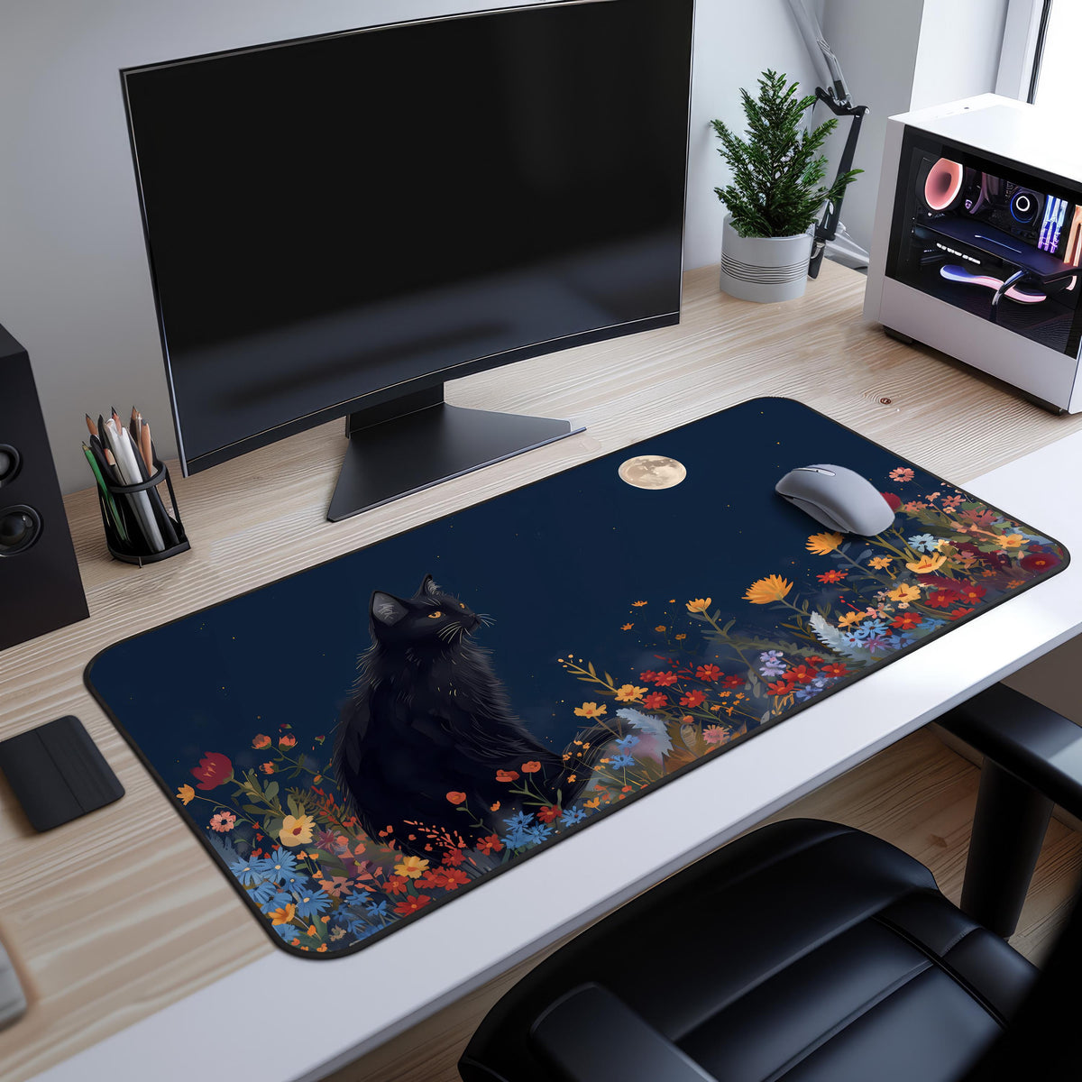 Black Cat And The Moon Desk Mat shown from above on a wooden desk with monitor, mouse and plant.