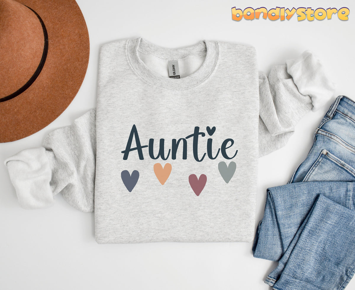 Boho Auntie Sweatshirt in ash laid flat on white beside a brown hat and blue jeans.