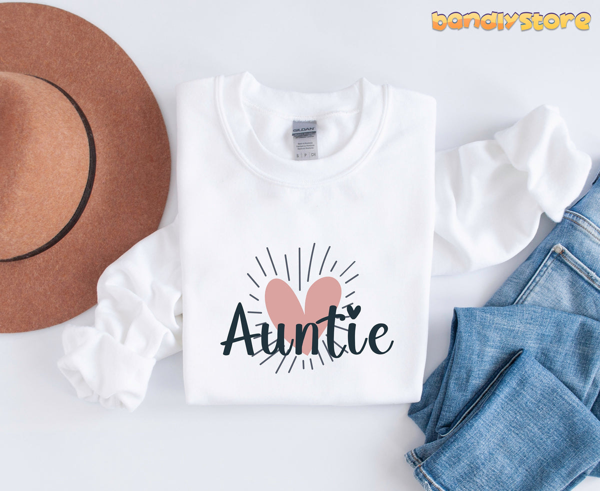 Boho Auntie Sweatshirt white, top-down flat lay next to brown hat and blue jeans.