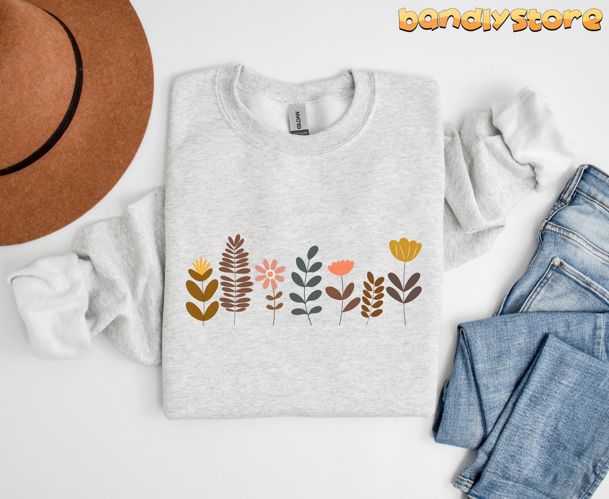 Cute Boho Wildflowers Sweatshirt in ash, folded flat beside a brown hat and blue jeans.