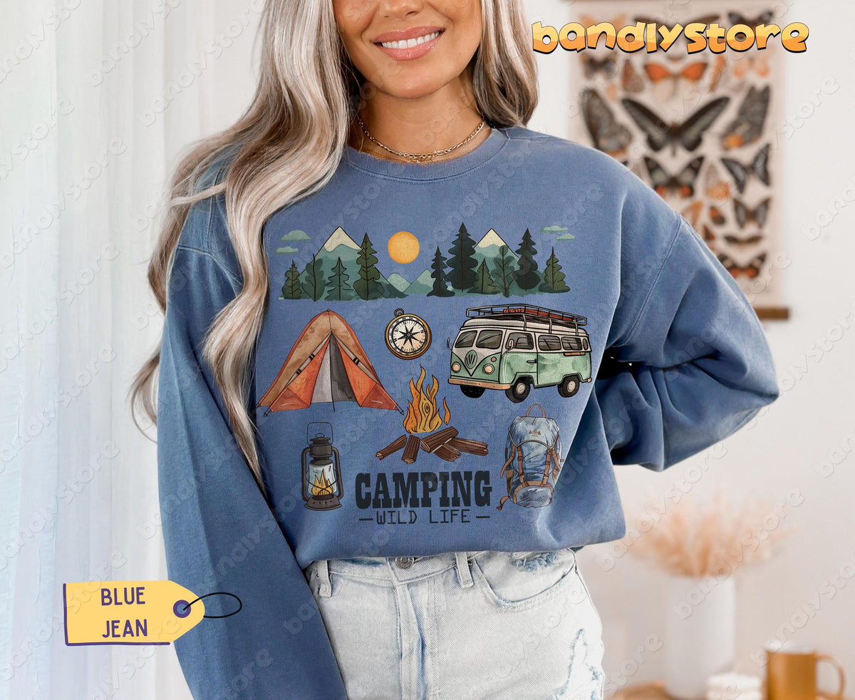 Camping Wildlife Sweatshirt in Blue Jean worn front-facing by a model beside white curtains and a butterfly poster.
