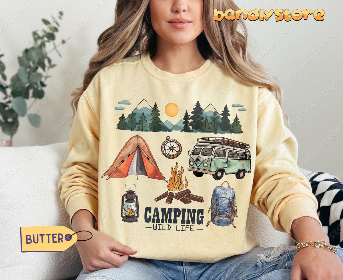 Camping Wildlife Sweatshirt in Butter on a seated model facing forward showing tent, van, fire and mountains.