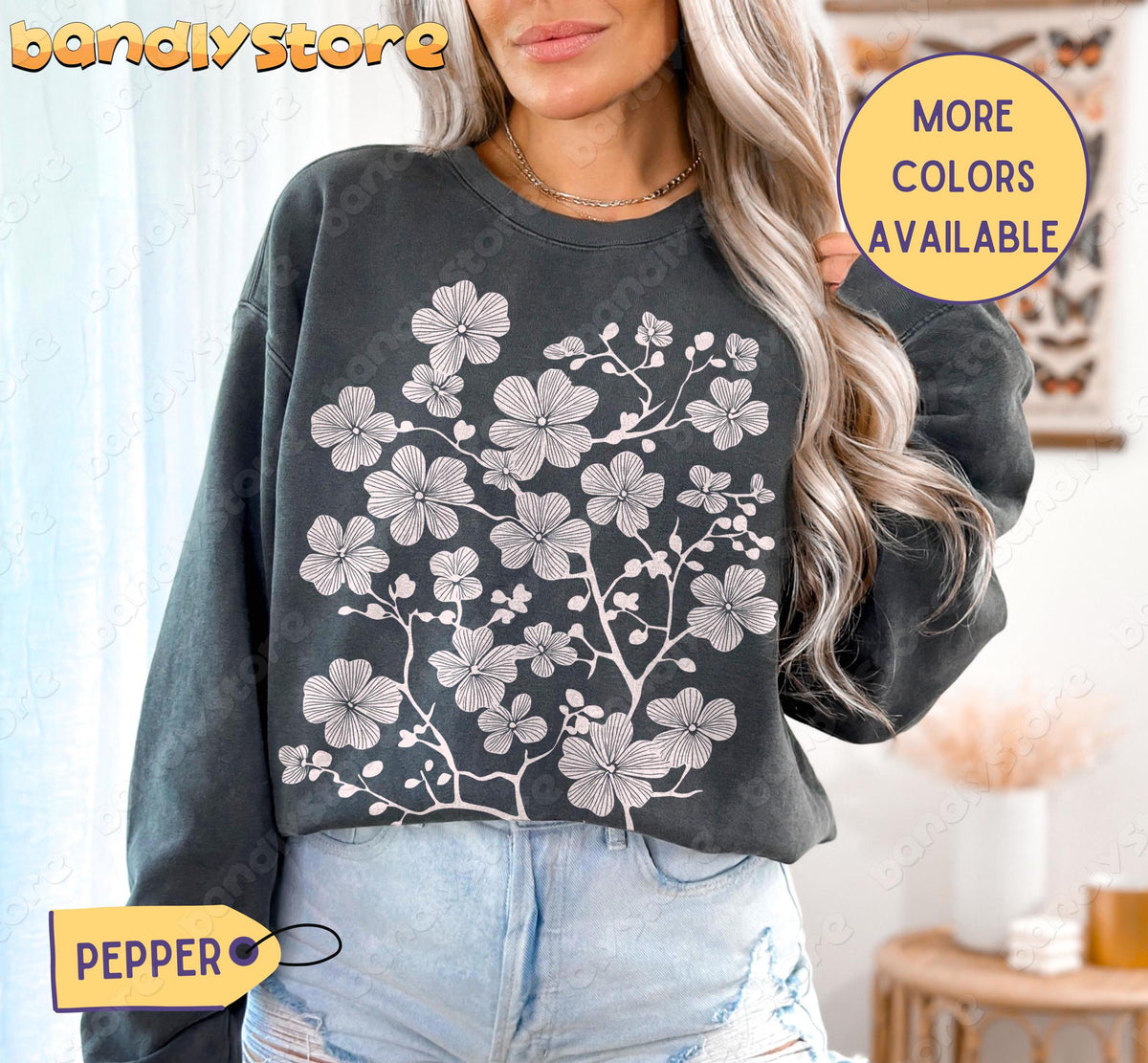 Cherry Blossom Linocut Sweatshirt in pepper on a woman standing indoors in front of sheer curtains.