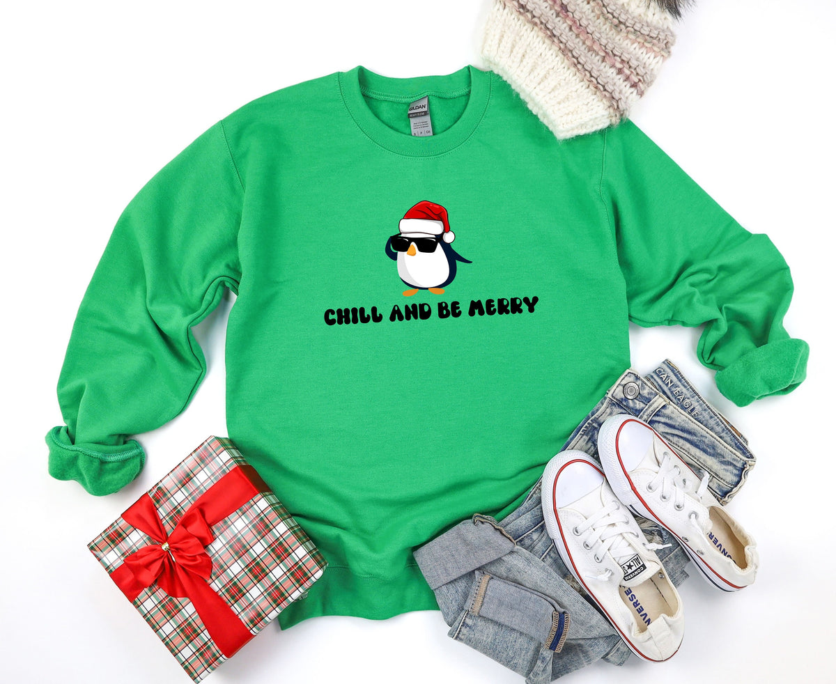 Chill And Be Merry Penguin Sweatshirt in Irish Green, flat-laid with gift, beanie, jeans and sneakers.