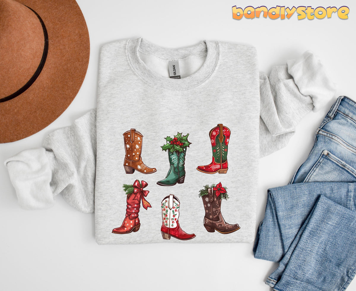 Christmas Cowgirl Boots Sweatshirt in ash, folded flat beside a brown hat and blue jeans.