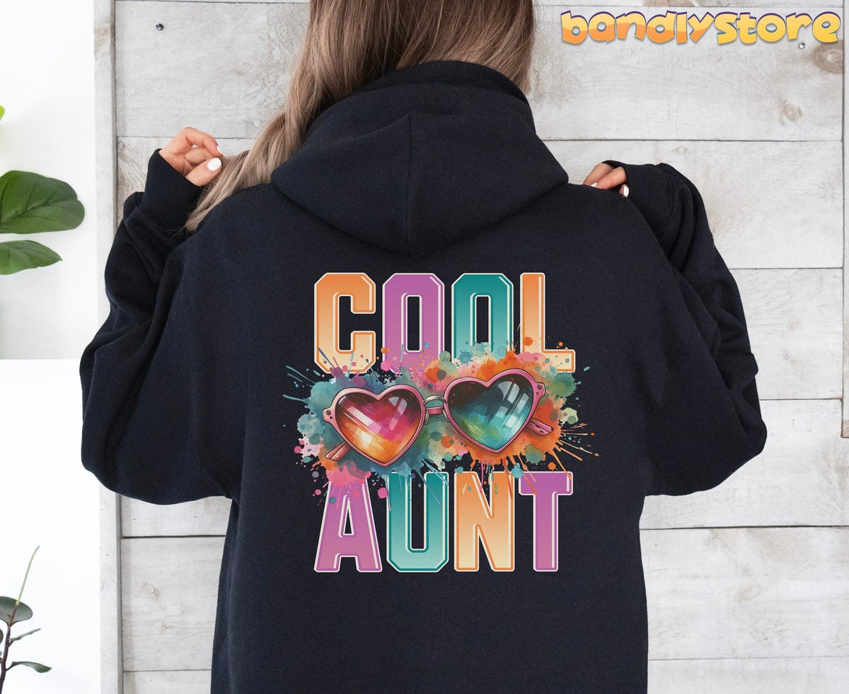 Cool Aunt Hoodie black rear view on person against wooden wall with green plants.