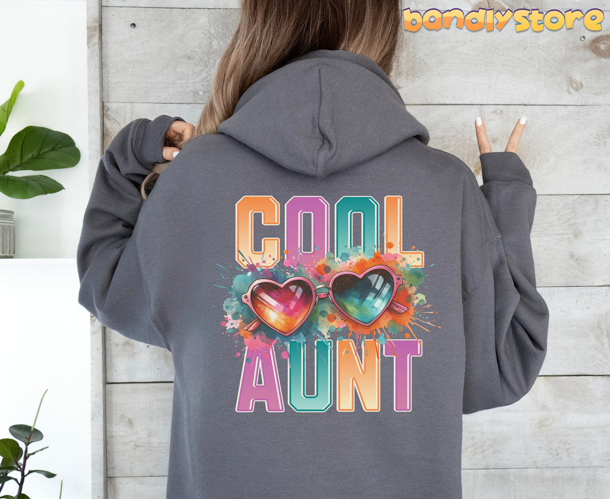 Cool Aunt Hoodie in charcoal worn from behind by a person against a wooden wall with plants.