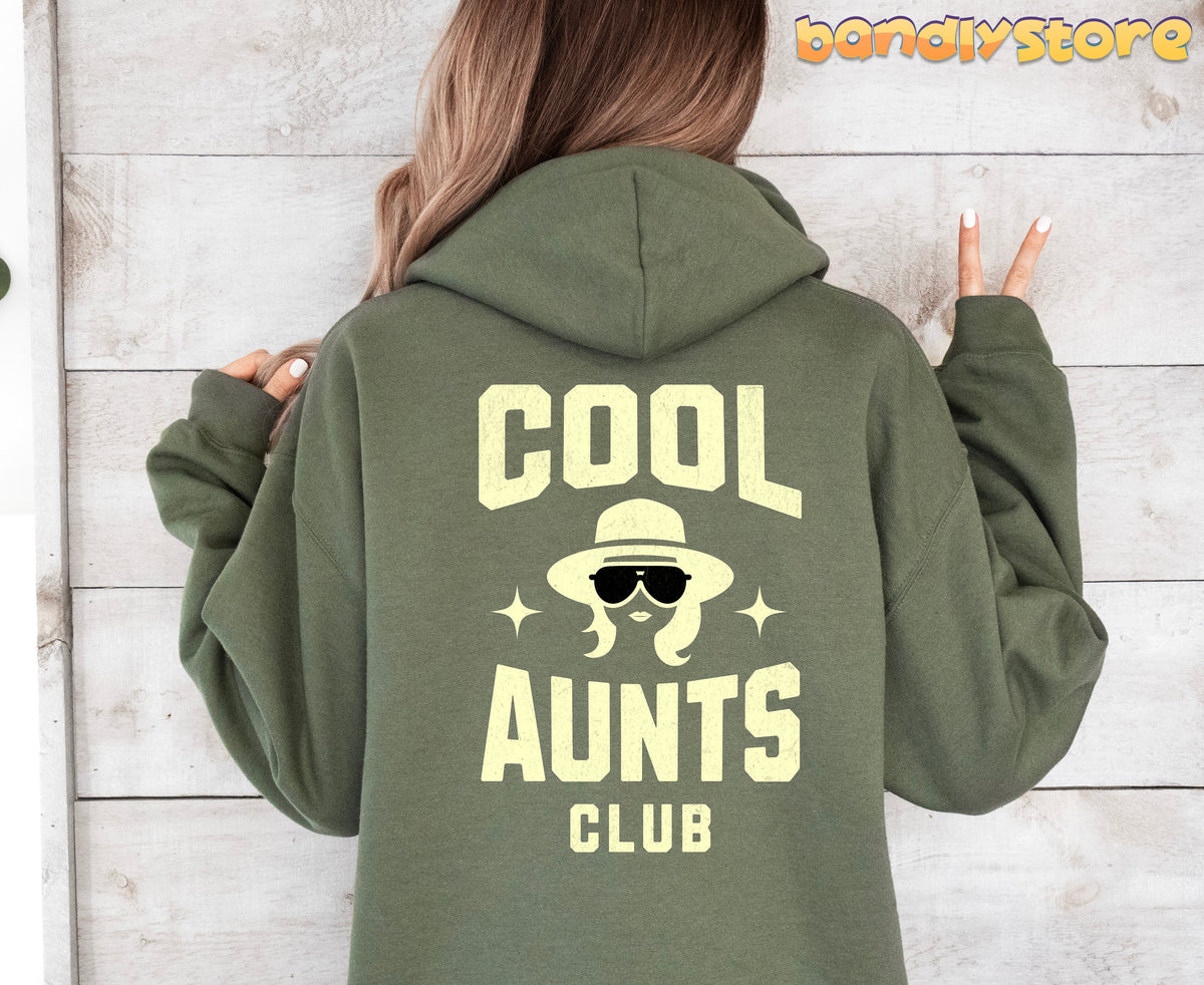 Cool Aunts Club Hoodie in military green worn from behind against a light wood wall.
