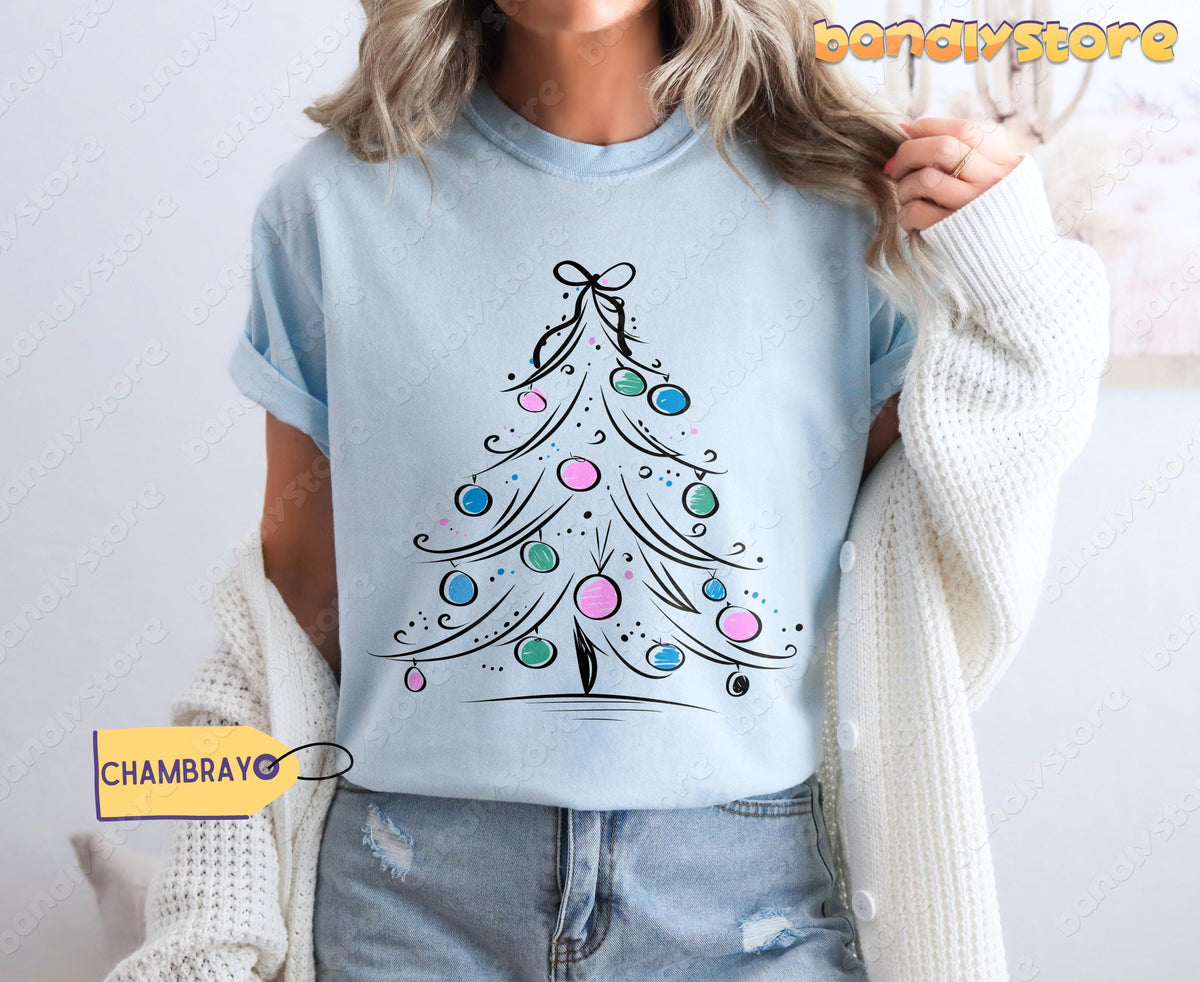 Coquette Christmas Tree T-Shirt in chambray shown on a person from the front with cardigan and jeans.