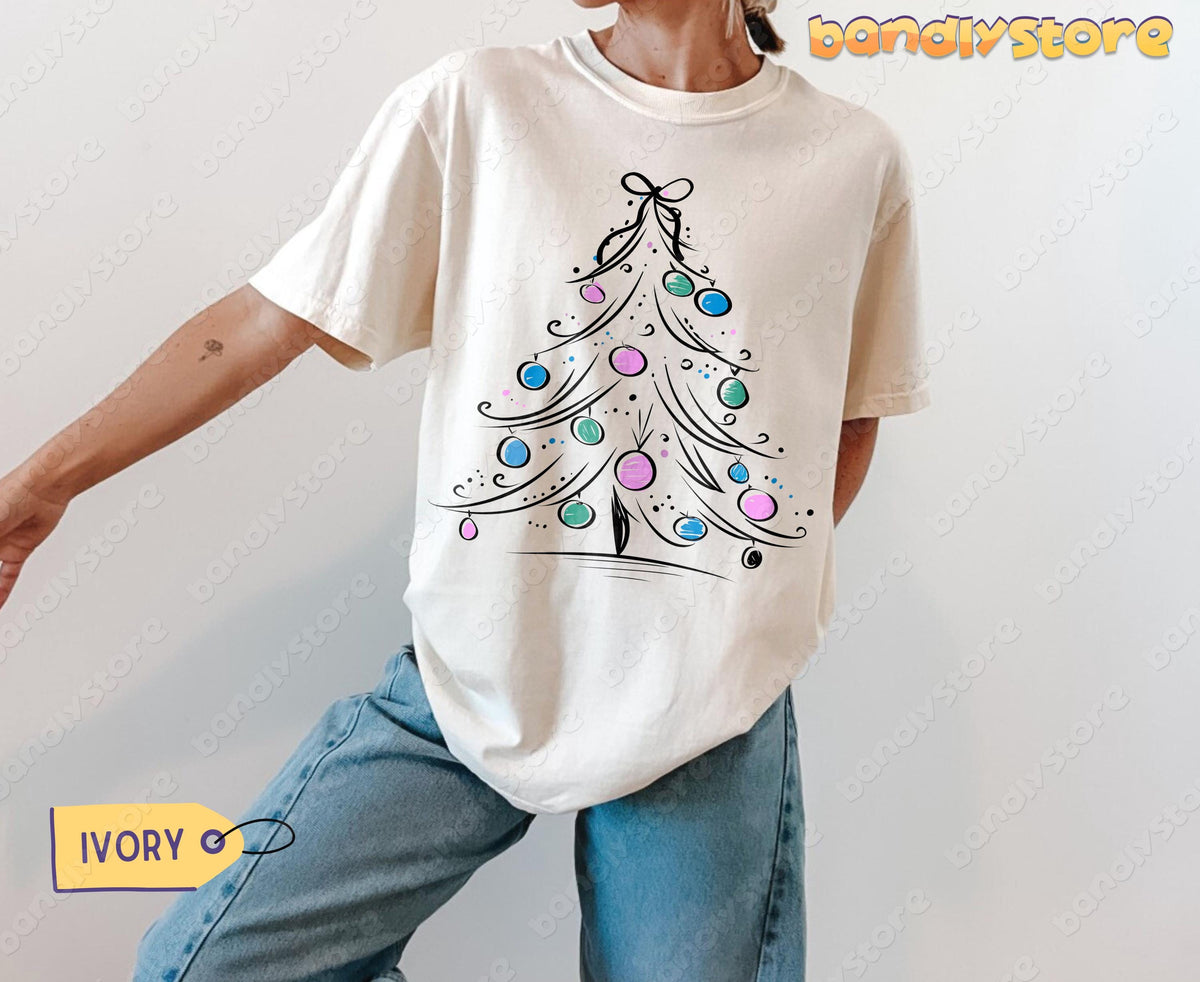 Coquette Christmas Tree T-Shirt in ivory worn frontally by a model in jeans against plain background.