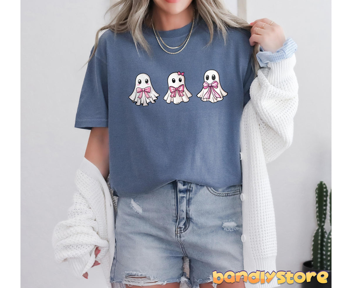 Cute Coquette Ghost T-Shirt in blue jean on a model in front view holding a cardigan beside a potted cactus.