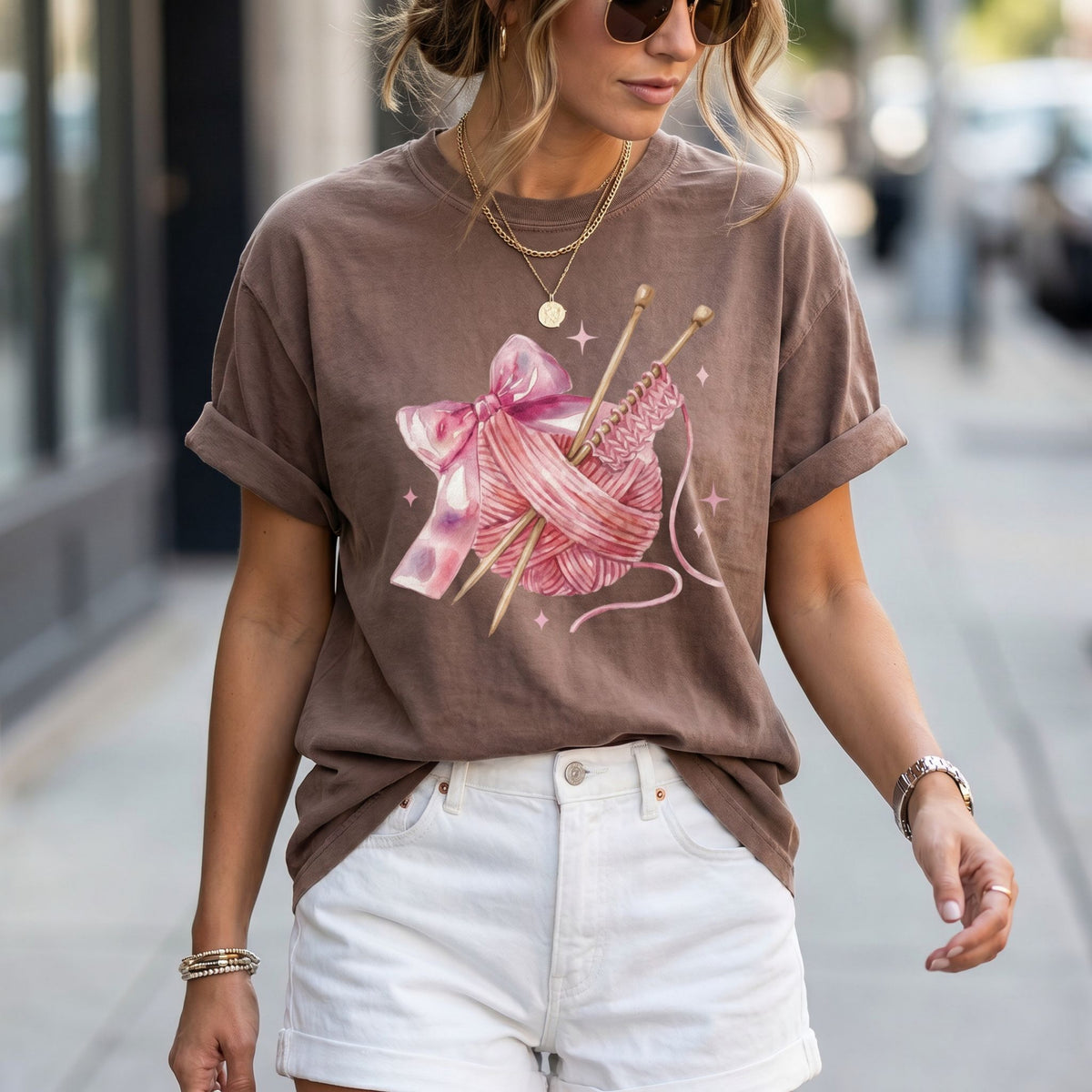 Cute Coquette Knitting T-Shirt in espresso worn by a woman on a city sidewalk, front view.