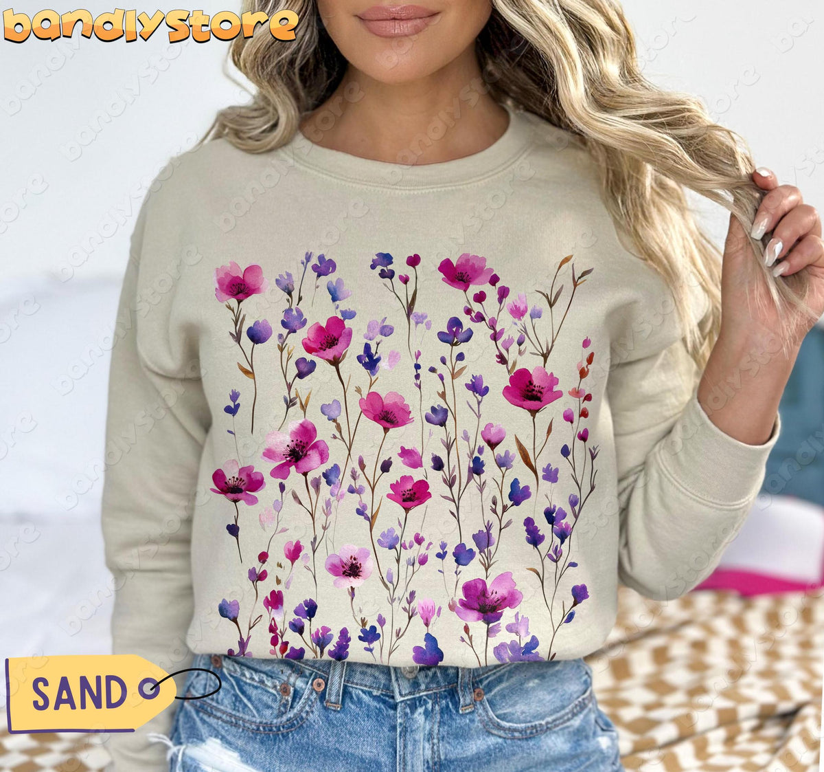 Pressed Wildflowers Sweatshirt in sand, front view on model holding hair beside bed.