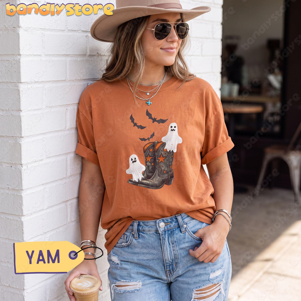 Vintage Cowgirl Boots and Ghosts T-Shirt in Yam on a woman leaning against a white brick wall holding coffee