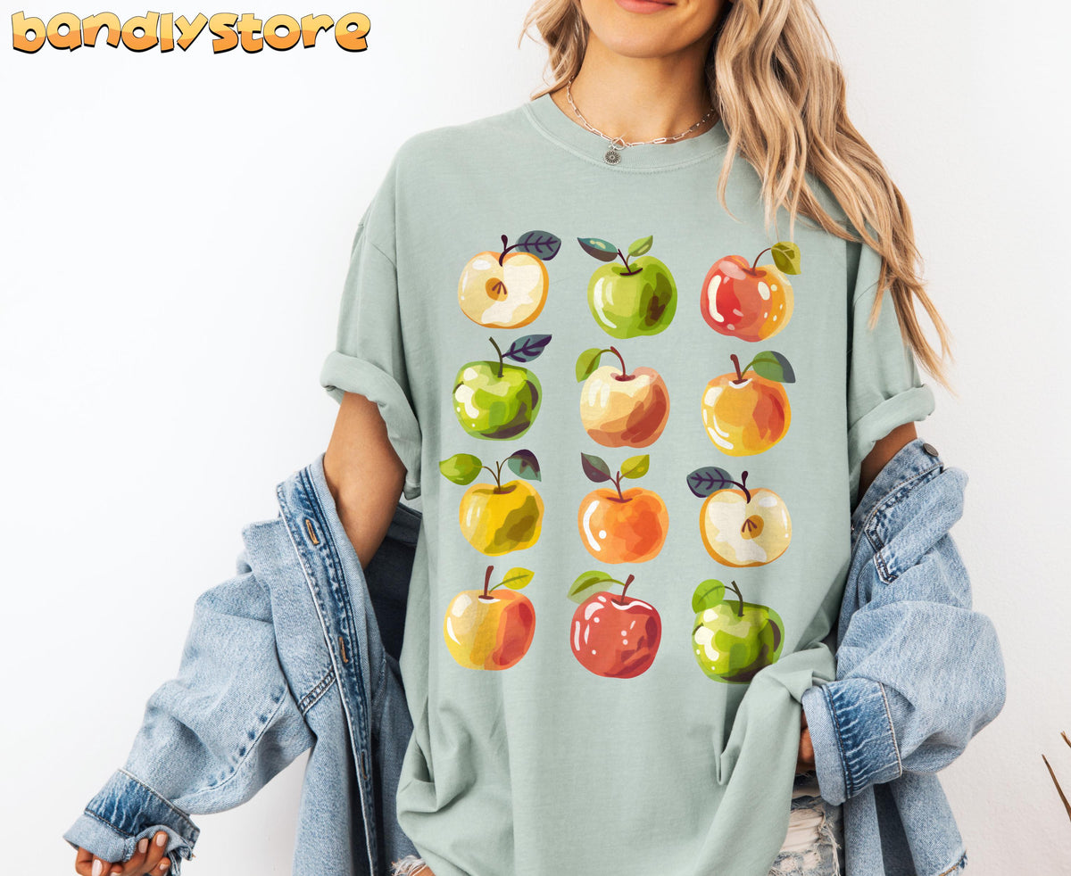 Cute Apples T-Shirt worn front-facing by a person with a denim jacket against a white wall in Bay