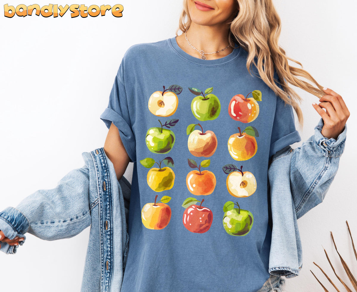 Cute Apples T-Shirt worn front-on by a person against a white wall with denim jacket and necklace in Blue Jean