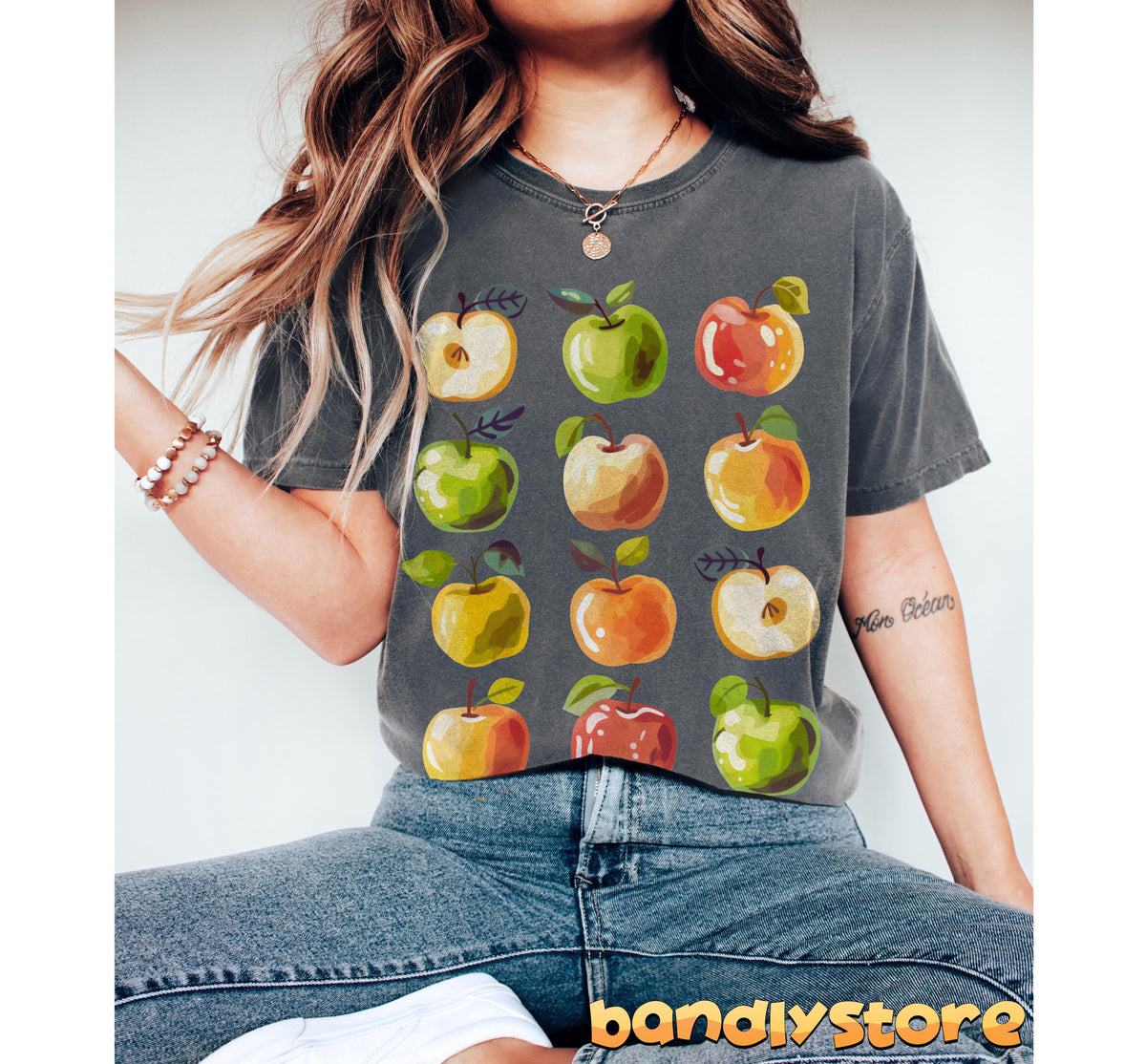 Cute Apples T-Shirt on a seated model in jeans, front view, grey tee with apple print against plain backdrop in Pepper