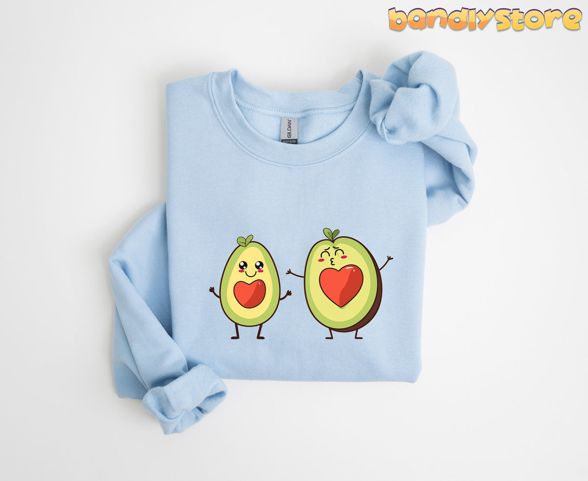 Cute Avocado Love Sweatshirt light blue folded flat on a plain white background viewed from above.