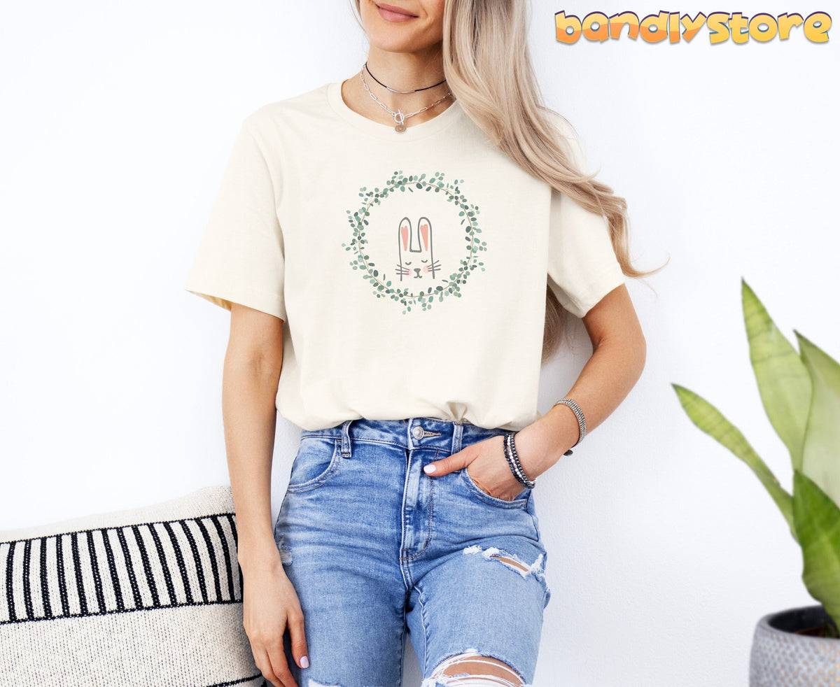 Cute Bunny T-Shirt in Natural on a model in front view against a white wall with a striped pillow and plant.