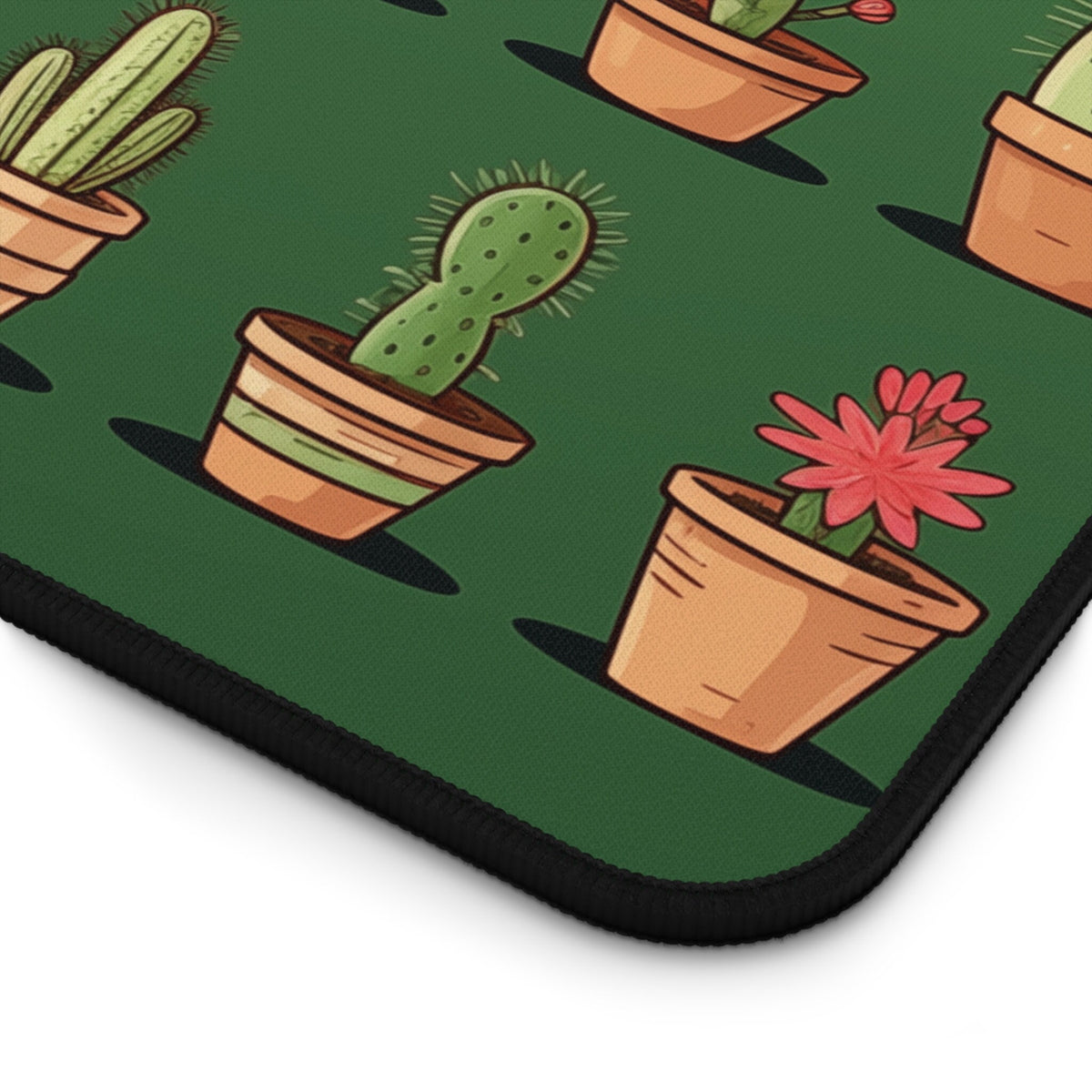 Cute Cacti Desk Mat detail of the corner with potted cactus illustrations on green fabric and black stitched edge.