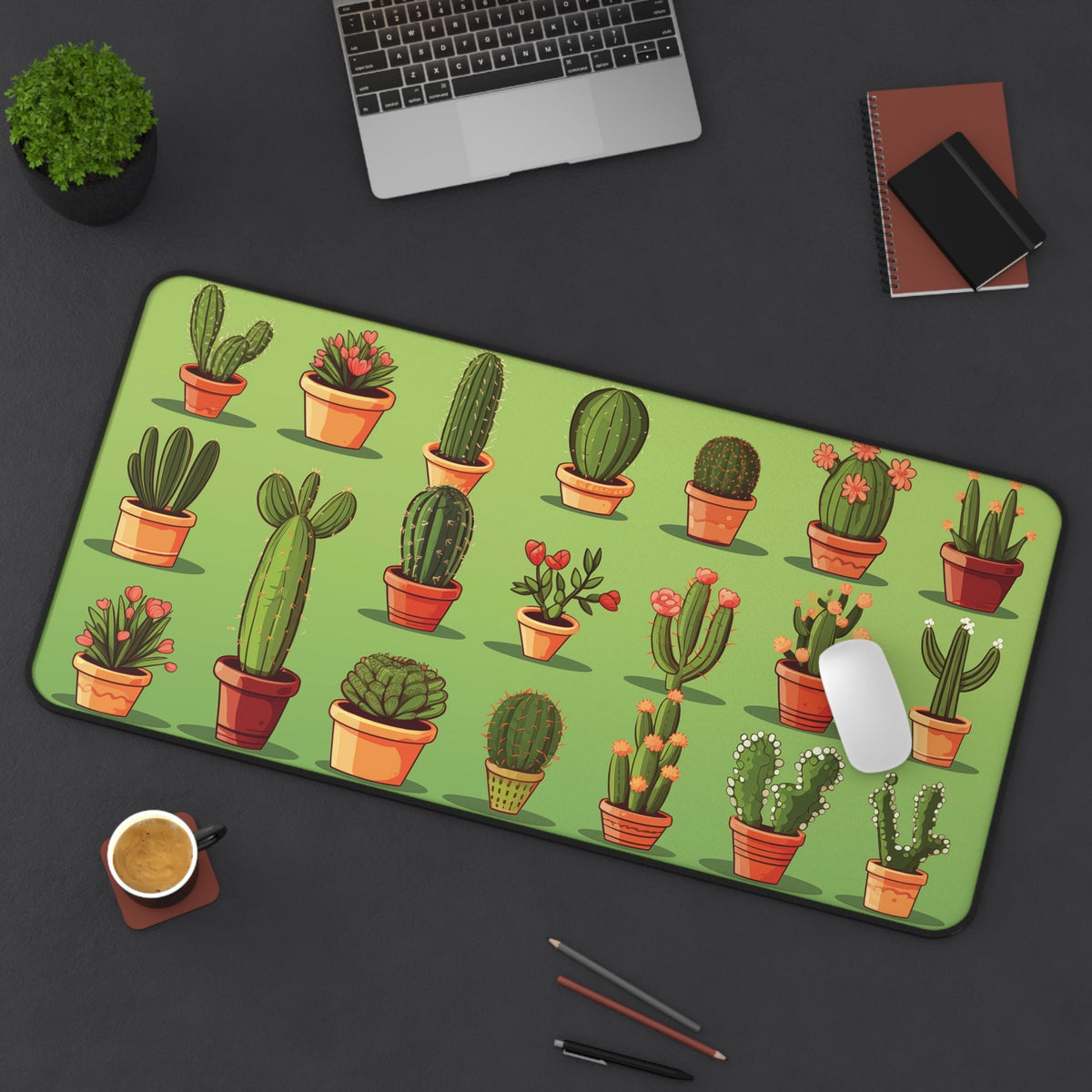 Cute Cactuses Desk Mat 16 × 32 inches atop a dark desk with laptop, plant, notebooks, coffee, pens and mouse.