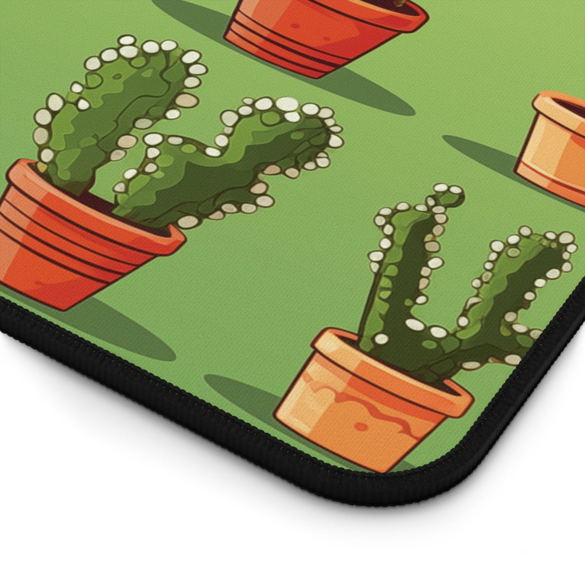Cute Cactuses Desk Mat detail of corner showing potted cactus prints and black stitched edge.