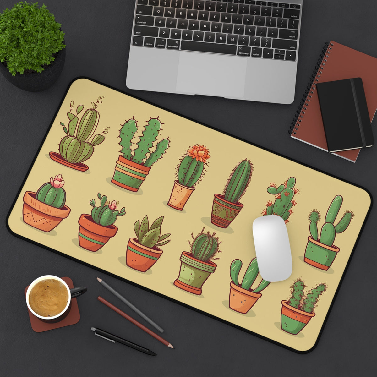 Cute Cactuses Desk Mat on a desk with laptop, plant, coffee, notebooks and mouse; pale yellow 12 × 22 inches.