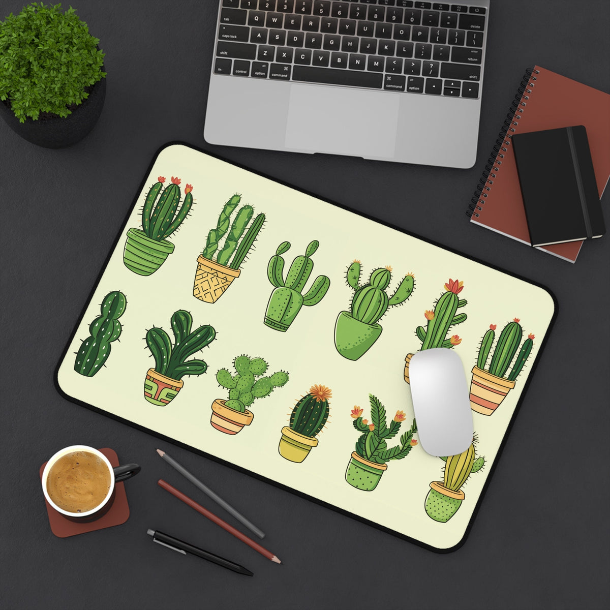 Cute Cartoon Cactus Desk Mat shown top-down at 12 × 18 inches on a dark desk with laptop, plant, coffee, pens and mouse.