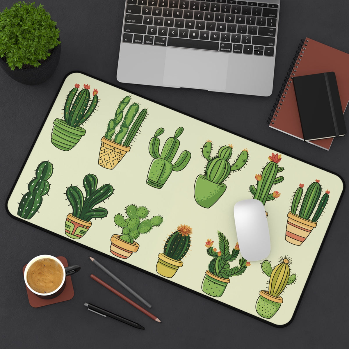 Cute Cartoon Cactus Desk Mat 12 × 22 inches from above on a desk with laptop, plant, coffee, pens and notebooks.