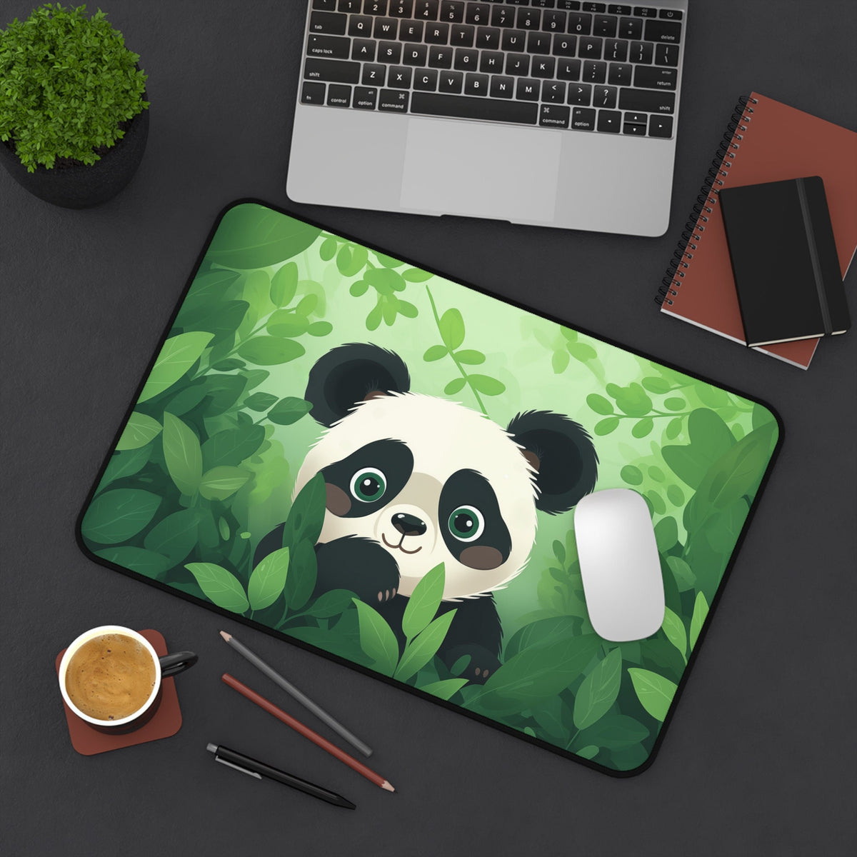 Cute Kawaii Panda Desk Mat on a dark desk with laptop, plant, coffee, pens and notebooks, green jungle panda design, 12 × 18 inches.