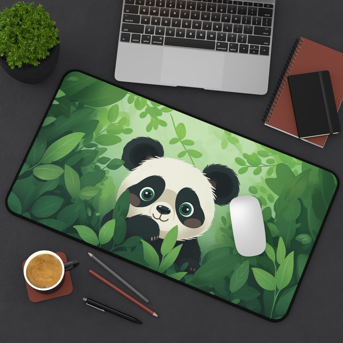 Cute Kawaii Panda Desk Mat on a dark desk with laptop, plant, coffee, pens and notebooks, 12 × 22 inches.